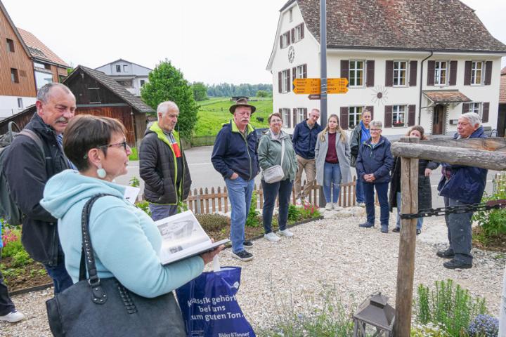Rémy Suter (links) und Helene Koch (im Vordergrund) erzählen Geschichten zum 1826/27 erbauten Schulhaus (im Hintergrund). Bilder Elmar Gächter