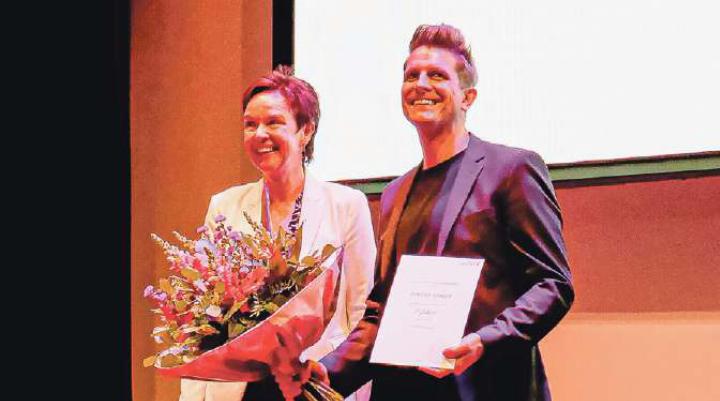 Urkunde und Blumen aus den Händen von Regierungsrätin Monica Gschwind für Flavian Graber an der Baselbieter Kulturpreisverleihung. Bild zvg