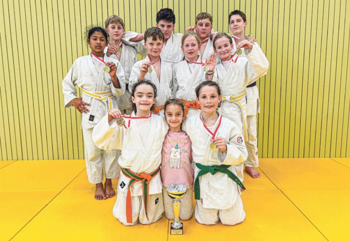 Die erfolgreiche Turniermannschaft des Judo Liestal präsentiert stolz den erkämpften Pokal und die gewonnenen Goldmedaillen. Bild zvg