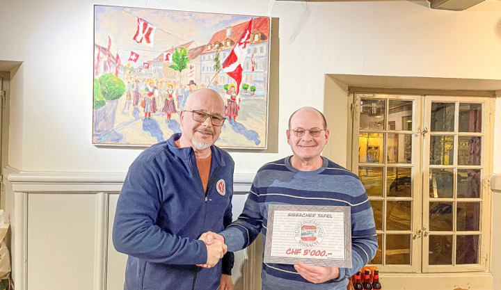 Bürgerratspräsident Christoph Tschan (links) überreichte den Check aus dem Erlös des Jubiläumsbierverkaufs an Pfarrer Gerd Sundermann, Vertreter der «Sissacher Tafel». Bild zvg