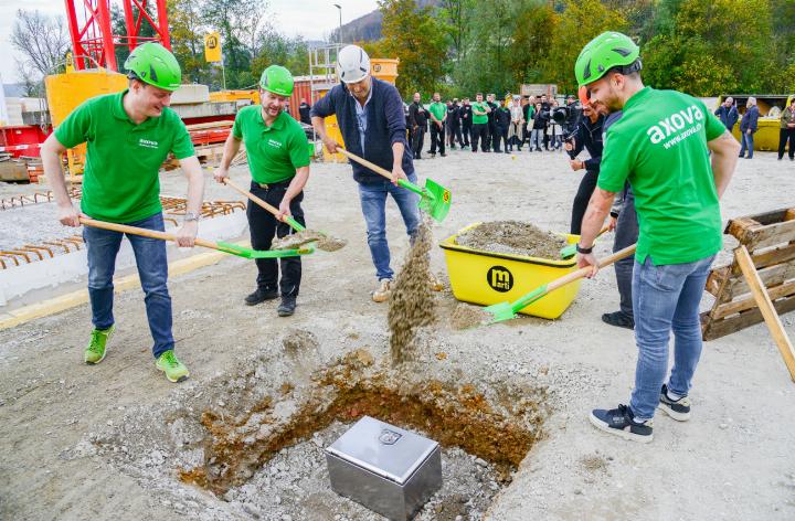 Beim Spatenstich vergruben Geschäftsführer Andreas Meier, Martin Kunz (Bereichsleiter Solar, Axova), Reto Kalt (Bauleitung Solvo AG), Ramadan Shabani (Bauführung Marti AG, roter Helm) und Filippo Presti ( Bereichsleiter Dach, Axova) (von links) eine Kiste mit Fotos vom Brand und Dokumenten zum Neubau. Bild ch.