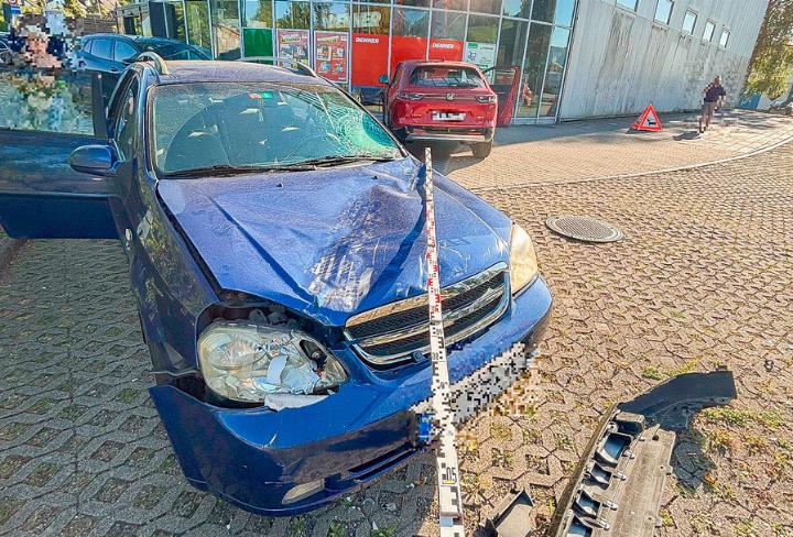 Bevor das rote Auto in die Scheibe des Einkaufszentrums prallte, fuhr es über ein geparktes Fahrzeug hinweg. Bild zvg / Polizei Basel-Landschaft