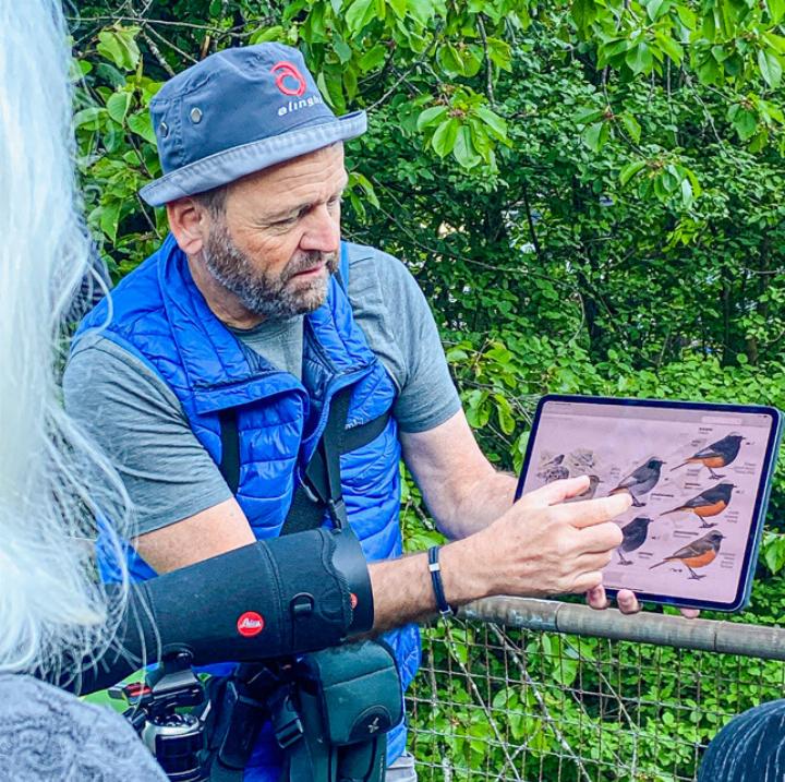Exkursionsleiter Niklaus Lang erklärt den Teilnehmern anhand Bildmaterial die gesichtete Vogelart. Bild Brigitt Buser