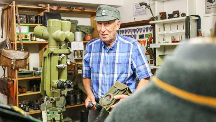 Hans Cleis mit einem Feldtelefon Modell 50 Ftf50, flankiert vom Grabenfernrohr aus dem Jahr 1940.