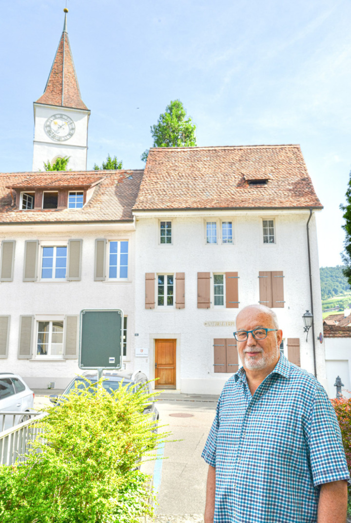 Autor Heiner Oberer vor dem Zuhause der Bitterlins, dem alten Schulhäuschen neben der reformierten Kirche. Bild Christian Horisberger