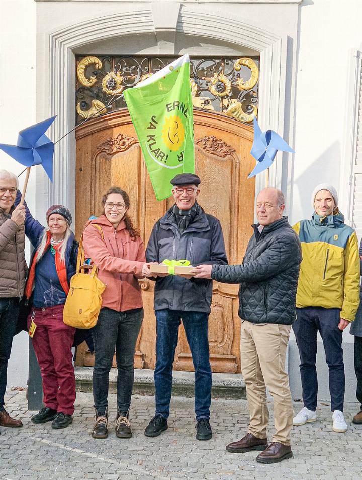 Sabine Mehring (rote Jacke) und Markus Stokar (Bildmitte) von «Pro Wind» übergeben dem 2. Landschreiber Nic Kaufmann die Petition. Bild Jo Krebs