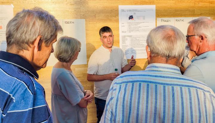 Gemeindepräsident Piero Grumelli erläutert der interessierten Bevölkerung eine Variante für mehr Schulraum. Bild nsc.