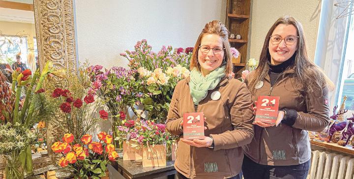 Rahel Nyfeler (links) und Dalia Manser von Blumen Pasadena präsentieren das Gutscheinbuch 2026.Bild zvg