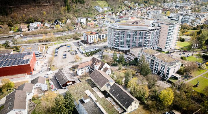 Zwischen Parkhaus (links, rot) und dem Bettentrakt soll in Liestal der Neubau zu liegen kommen. Bild Peter Sennhauser