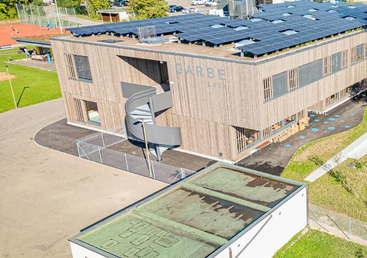 Auf dem Dach des Kindergartens Garbe wurden 250 Solarpanels montiert. Neben dem Gebäude bietet der Aussenbereich den Kindern verschiedene Spielmöglichkeiten.
Bilder Peter Sennhauser/Luana Güntert