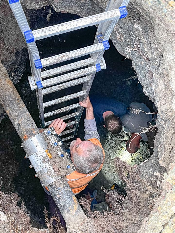 Teilnehmer des «Wasserleitungsbruch-Spaziergangs» steigen in die sechs Meter tiefe Doline hinab. Links die reparierte Wasserleitung. Bild Christian Horisberger