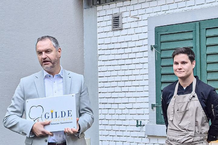 «Gilde»-Ambassador Eli Wengenmaier übergibt dem Sissacher «Krone»-Wirt Rino Zumbrunn das Schild. Bild zvg