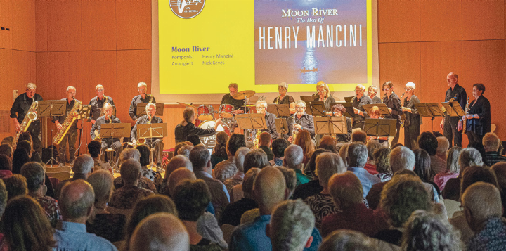 Das «Silverhorns Sax Orchestra» spielt vor vollem Haus im Gemeindesaal Zunzgen. Auf der Leinwand: «Moon River» von Henry Mancini, arrangiert von Nick Keyes.
Bild zvg
