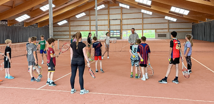 Die Fünftklässler aus Gelterkinden mit Lehrerin Eliane Schneeberger hören gespannt den Tipps vom Tennislehrer zu. Bild zvg
