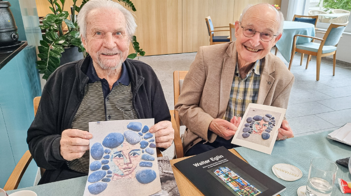 Toni Eglin (links) und Thomas Schweizer halten das zentrale Bildmotiv in den Händen: einen skeptisch blickenden Mädchenkopf, umgeben von viel Zement und einem kleinen runden Stein oben links.
Bild Lorenz Degen