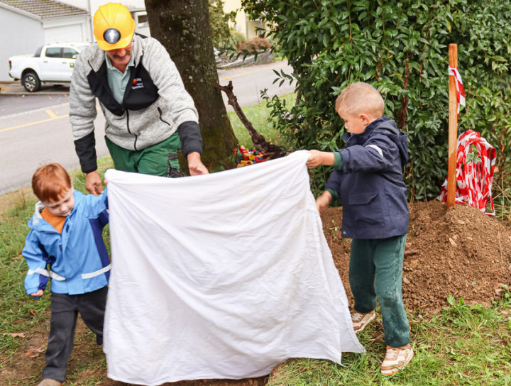 Kinder enthüllen mit Unterstützung von OK-Mitglied Markus Jenny den Gedenkstein. Beim Gedenkstein ist auch die Zeitkapsel vergraben. Bilder Brigitt Buser