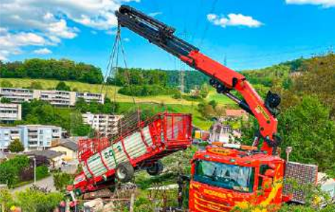 Traktor mit Ladewagen landet in einem Garten